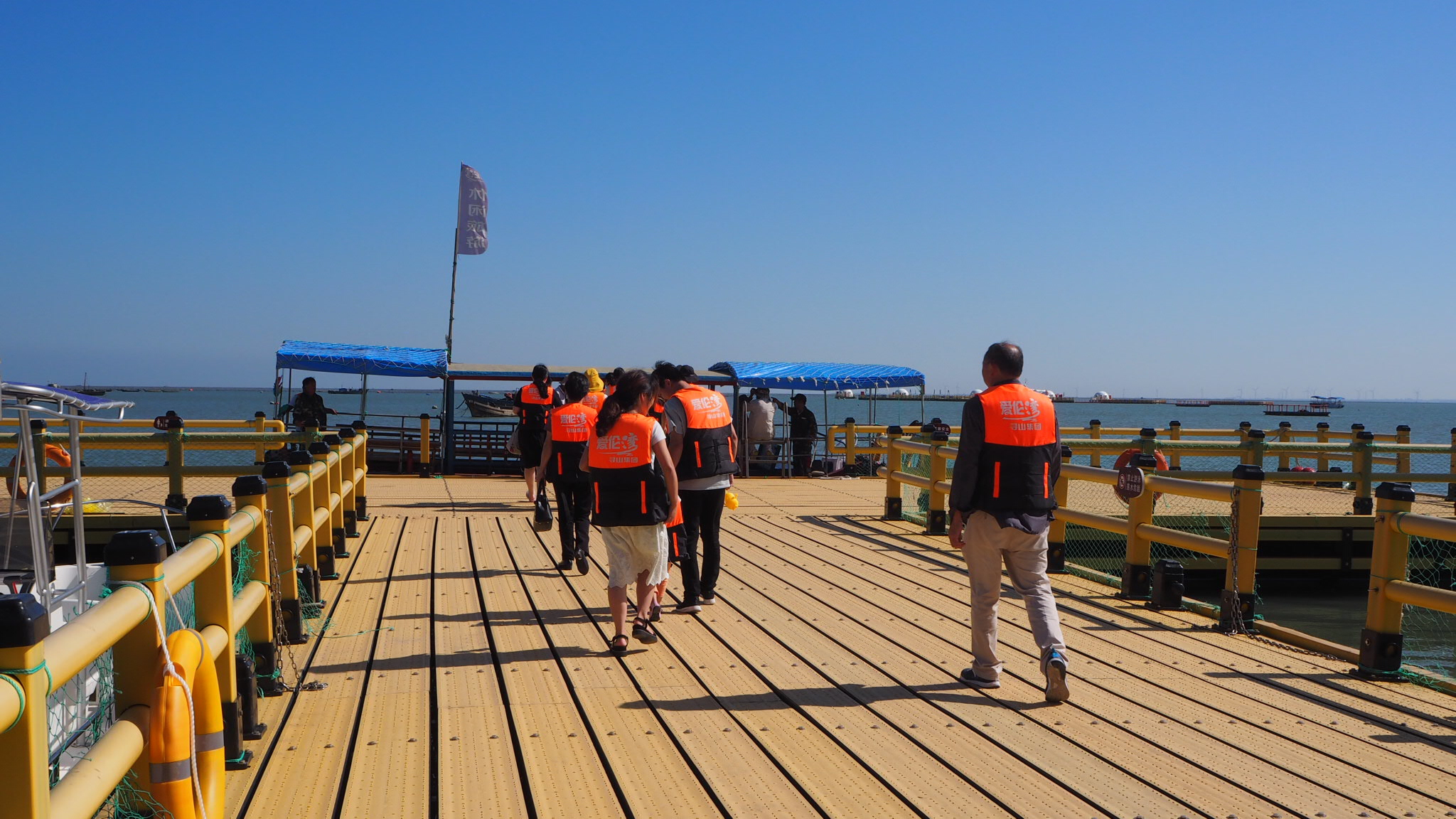 游客从海洋牧场码头乘船前往海上平台