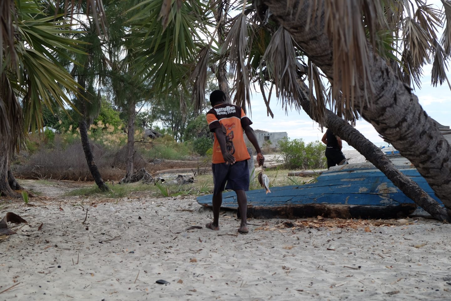 A Madagascan fishermen walks along the beach