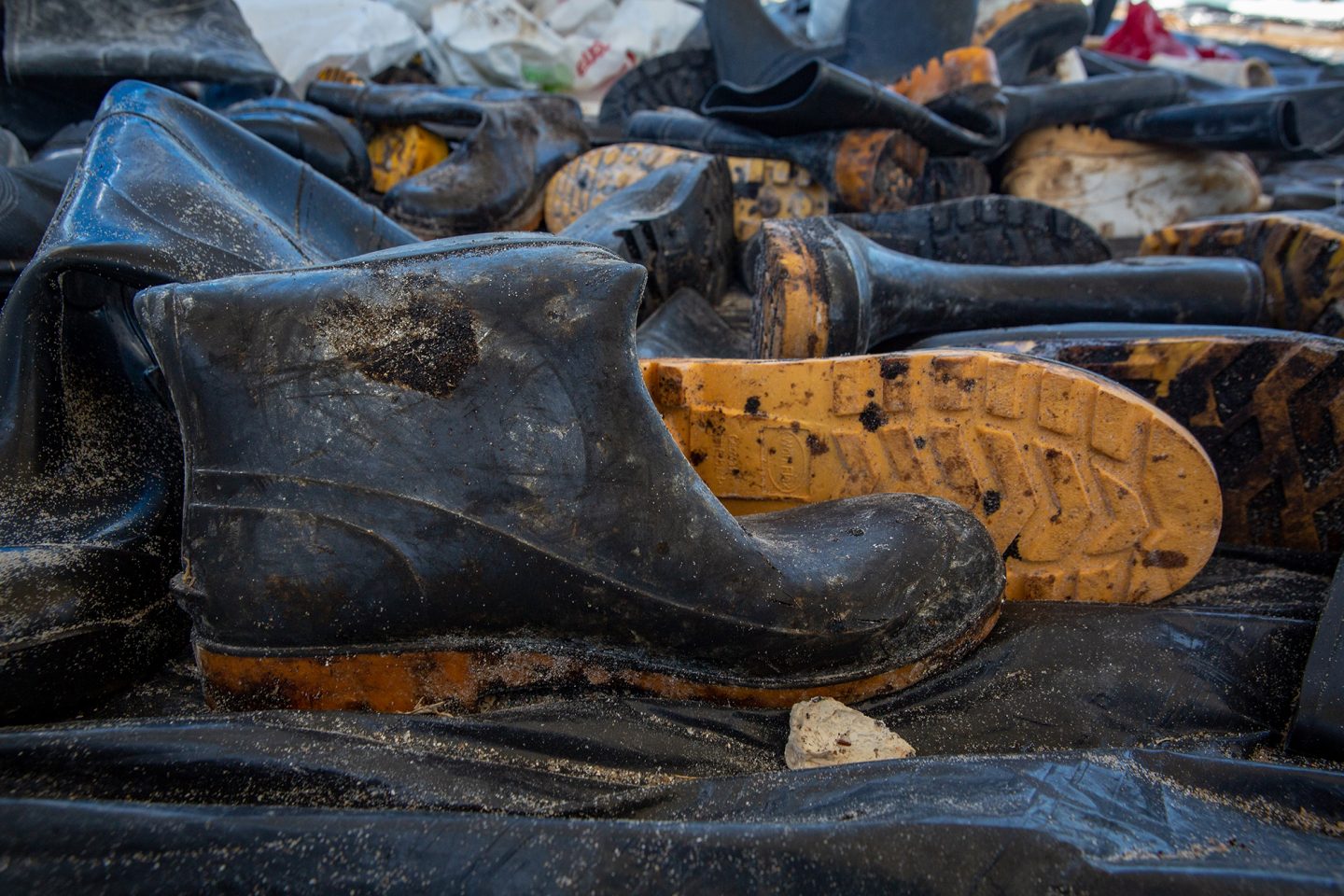 pile of black boots covered in oil from brazil oil leak 2019