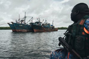 <p>一名冈比亚海军水手正在看守三艘被缉获的拖网渔船。这三艘渔船是海洋守护者协会在冈比亚沿海开展打击非法捕捞巡查行动中被查获的（图片©Leon Greiner/海洋守护者协会）</p>