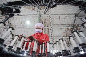 <p>A worker at a textile factory in Yanshanhe Village, Jiangsu province (Image: Alamy)</p>