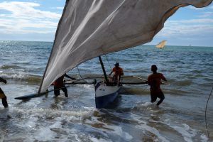 <p>Fishermen bring ashore their traditional canoe (Image: Ning Hui / Initium Media)</p>