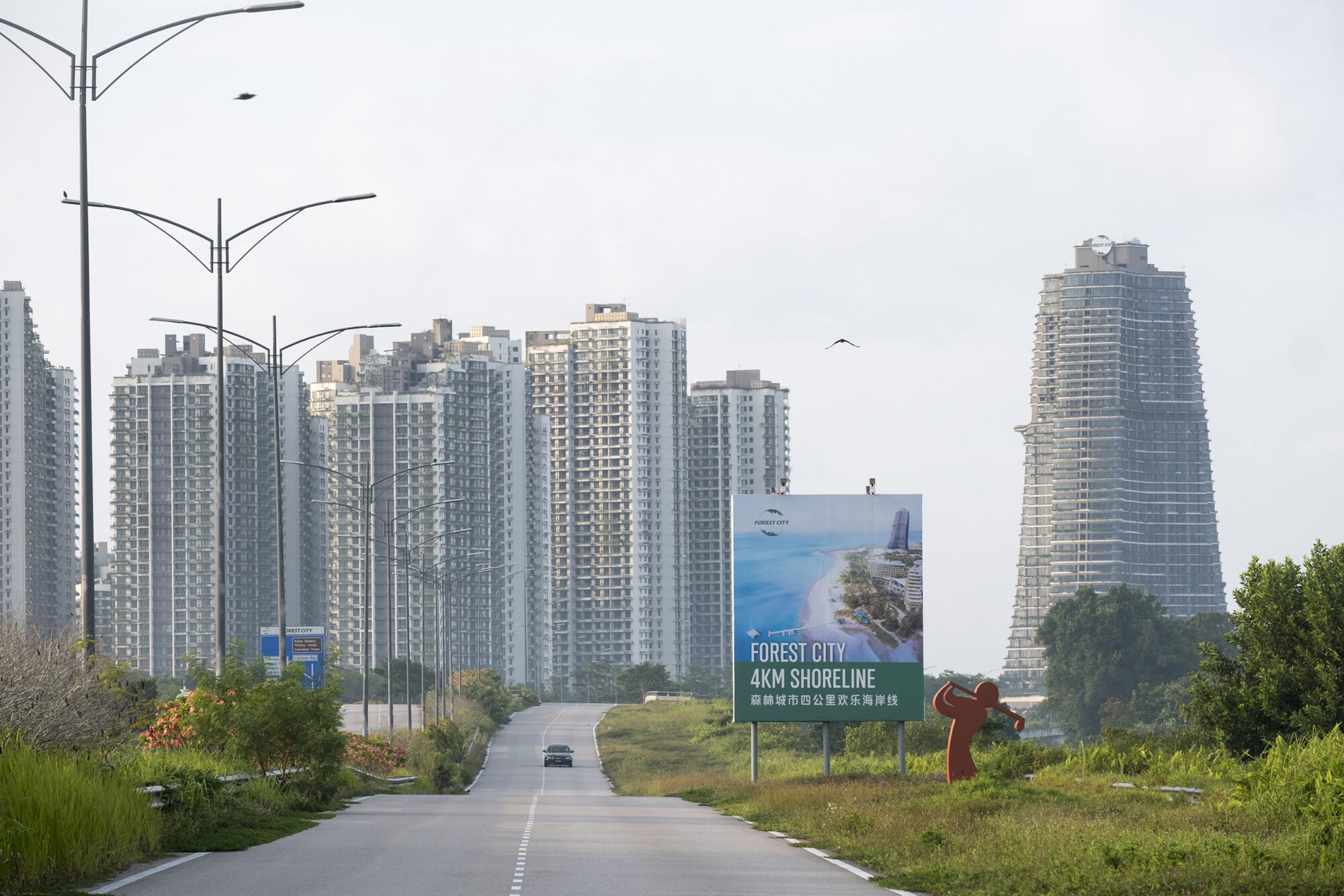 Advertisements are seen along the highway which links the reclaimed island on which Forest City was built to the mainland.