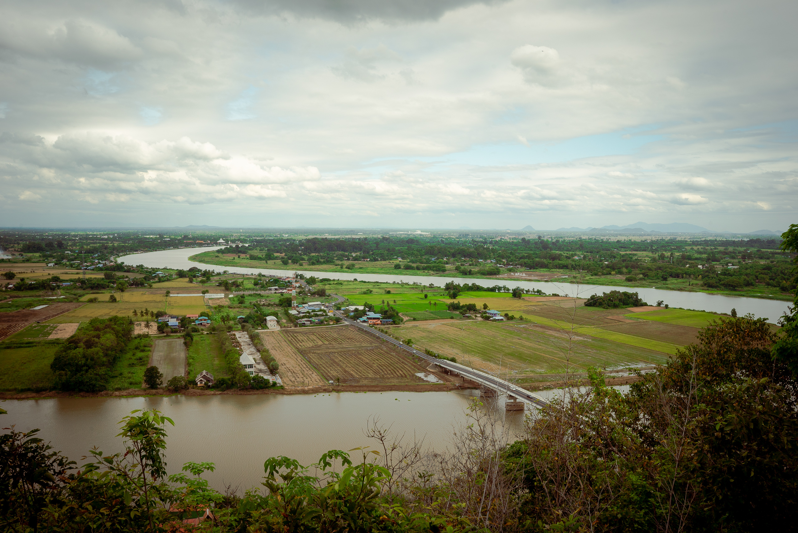 rows of agricultural fields on the bank of winding river