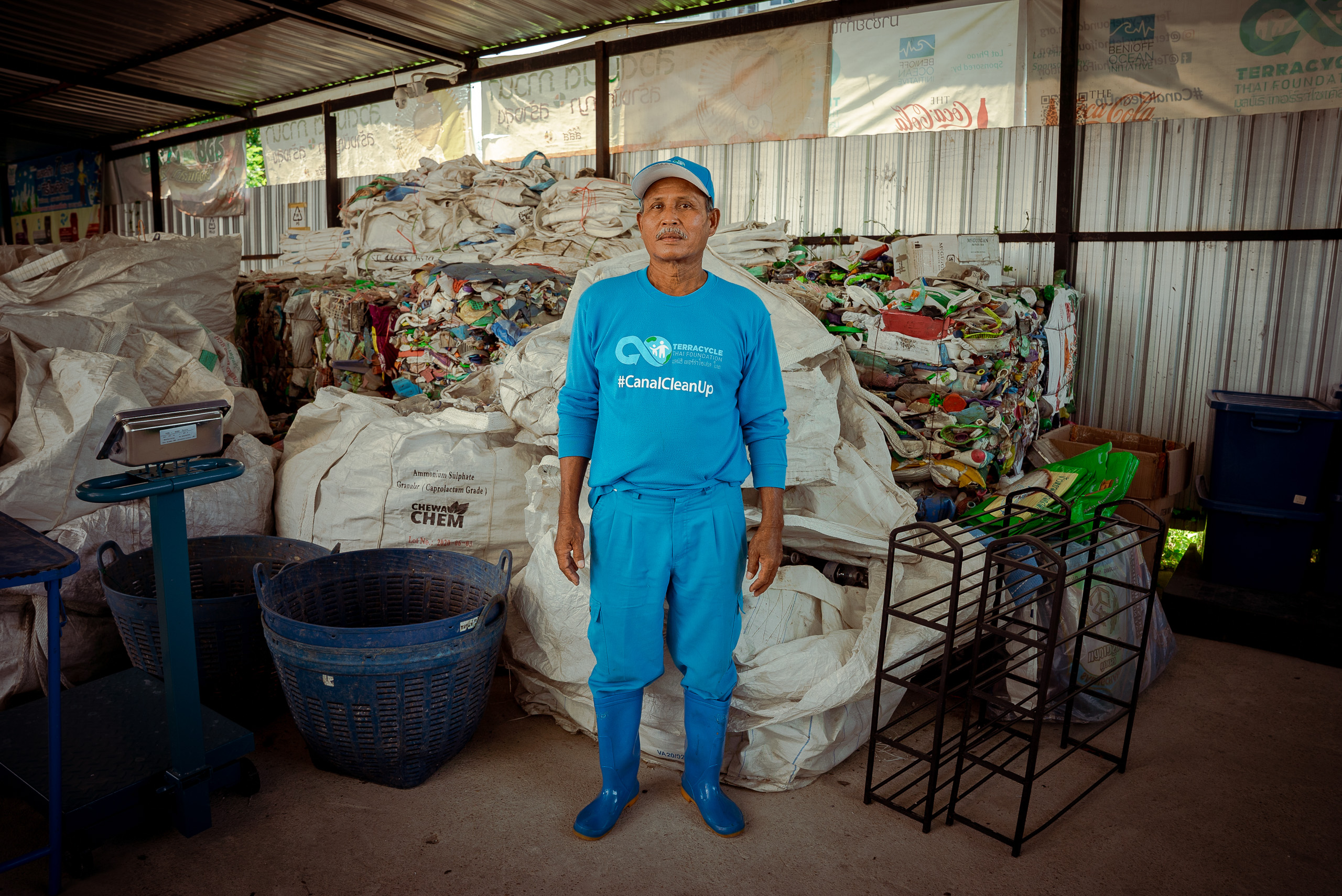 man standing in front of piles of waste