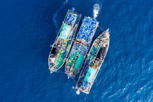 overhead view of three large fishing trawlers on ocean